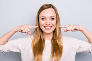 woman pointing to white smile, cosmetic dentistry baytown tx