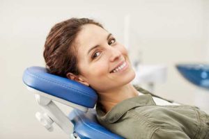 woman leaning back in dentist chair smiling periodontics baytown tx