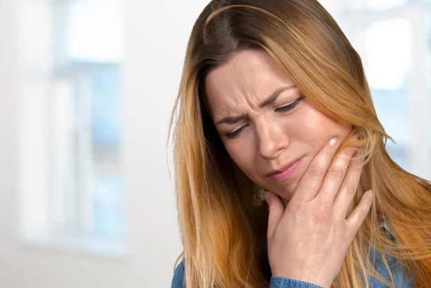 I have a dental emergency (3) woman wincing realizin I have a dental emergency