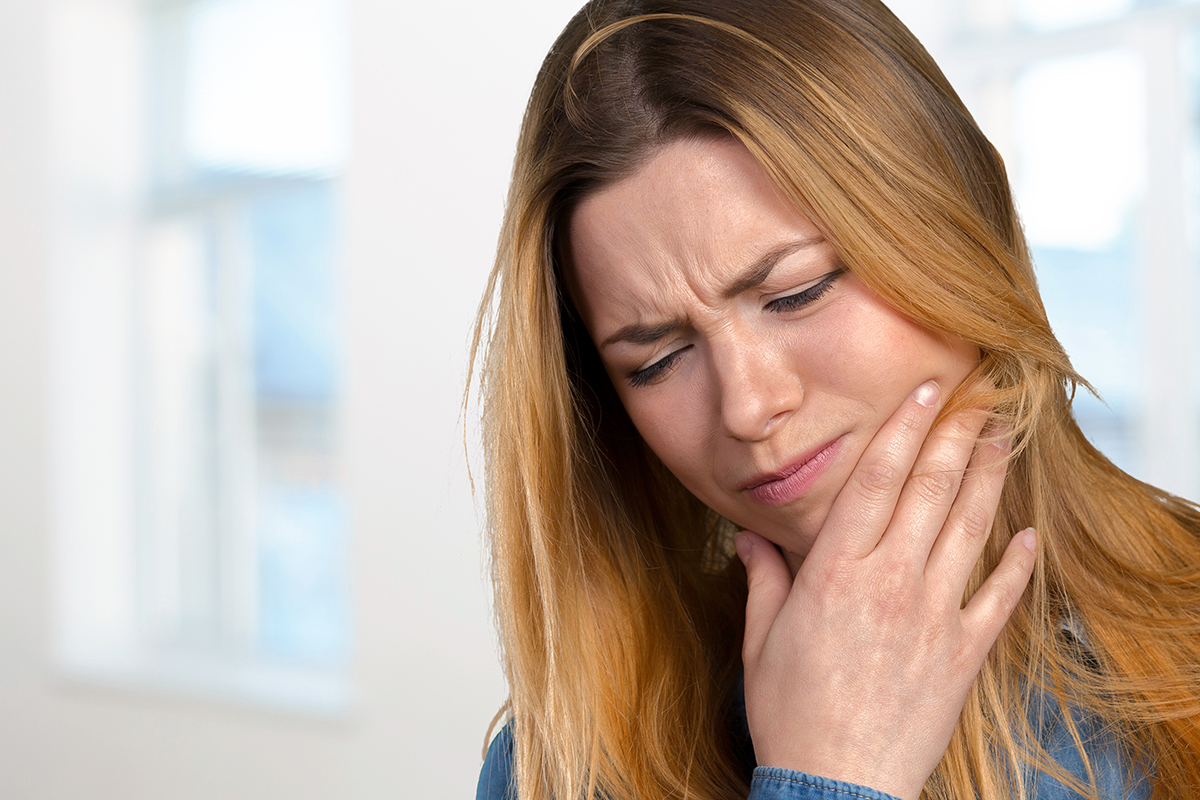 I have a dental emergency (3) woman wincing realizin I have a dental emergency
