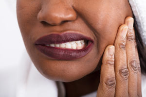 woman wincing from teeth grinding